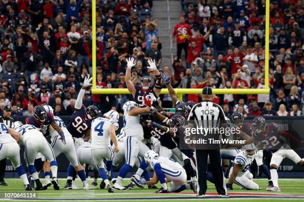 Adam Vinatieri of the Indianapolis Colts kicks a field goal to end the first half defended by J.J. Watt of the Houston Texans at NRG Stadium on...