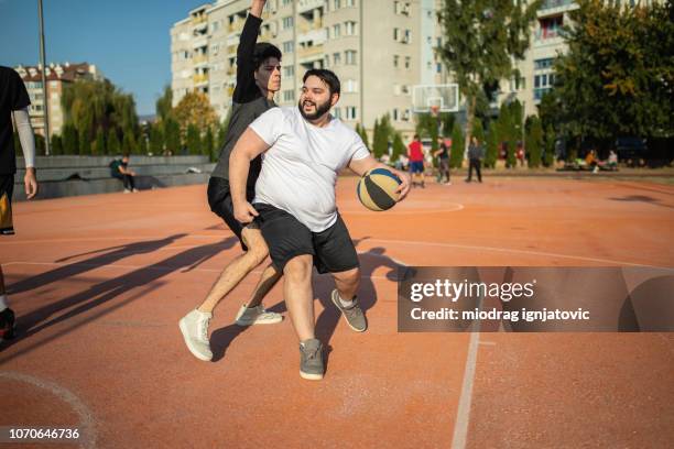 driving to the hoop - fat man stock pictures, royalty-free photos & images