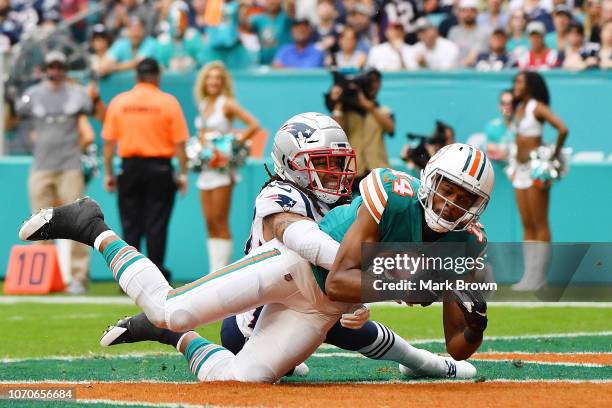 Brice Butler of the Miami Dolphins completes a pass for a touchdown against the defense of Stephon Gilmore of the New England Patriots during the...