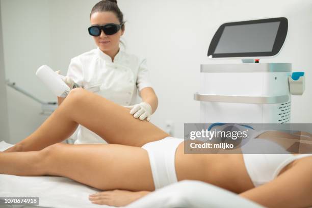 mujer joven en tratamiento de eliminación de pelo de láser - láser fotografías e imágenes de stock