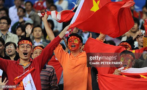 Chinese fans cheer for their athletes during day two action in the athletics competition at the 16th Asian Games in Guangzhou on November 22, 2010....