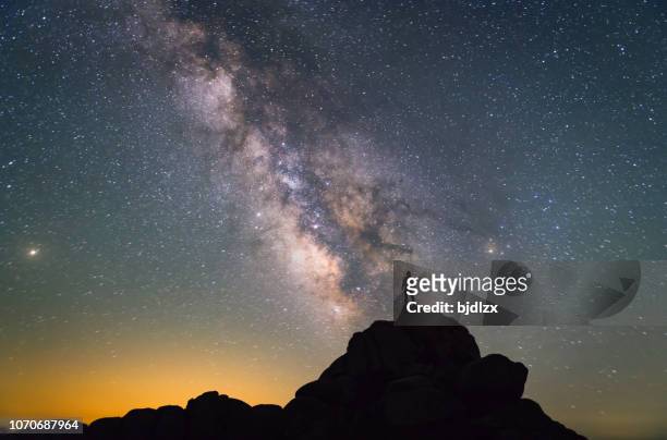 milky way. nachtelijke hemel en silhouet van een staande man - ontdekking stockfoto's en -beelden