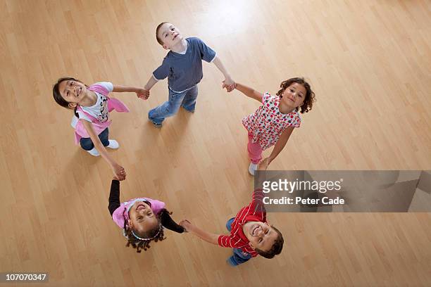 children skipping aroung in a circle - hold hands circle stock pictures, royalty-free photos & images