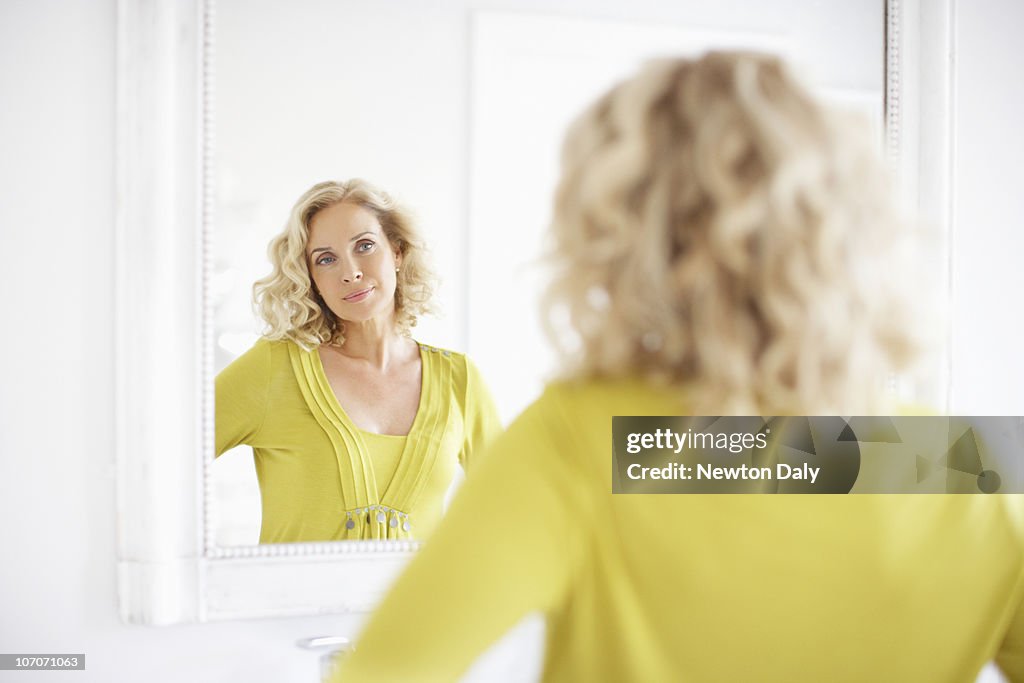 Mature woman looking in mirror