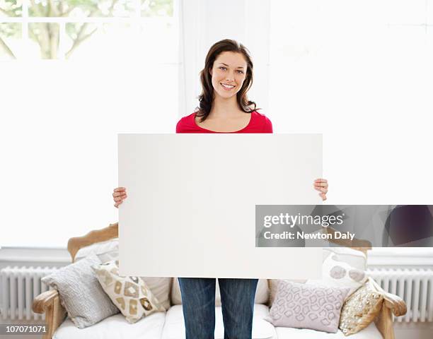 young woman holding up whiteboard - woman whiteboard stock-fotos und bilder