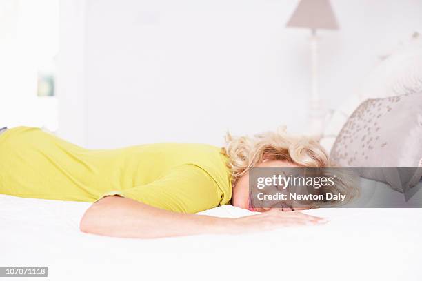 mature woman relaxing on bed - comfortable sleeping stock pictures, royalty-free photos & images