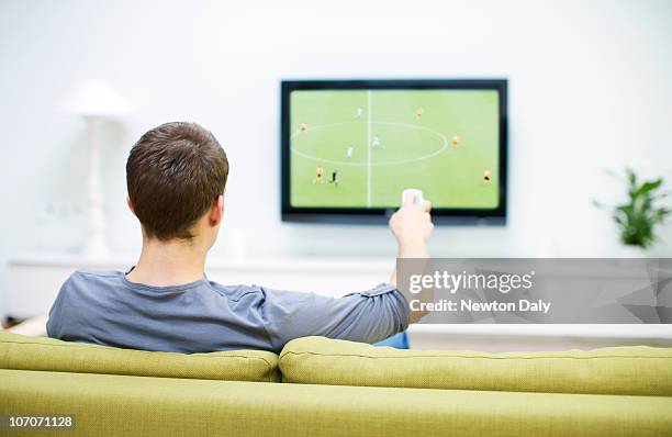 man watching football on television - man cave stock pictures, royalty-free photos & images