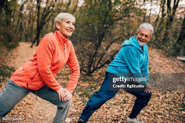 senior couple doing calf stretches in a park - female muscle calves stock pictures, royalty-free photos & images