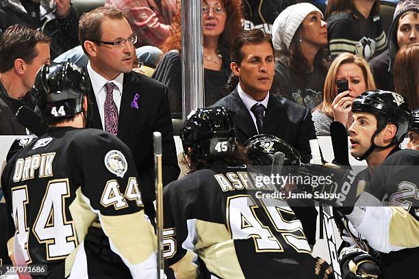 Head Coach Dan Bylsma and assistant coach Tony Granato of the Pittsburgh Penguins address the team during a timeout against the Carolina Hurricanes...