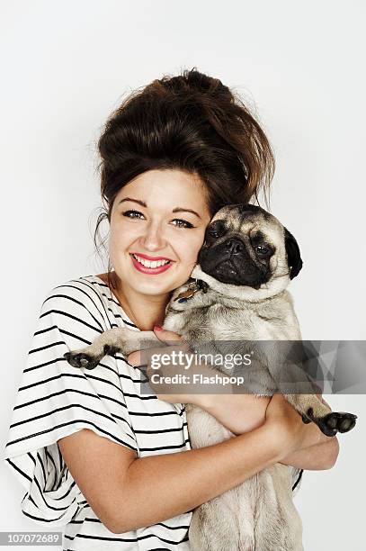 portrait of woman hugging her pet - woman holding dog studio stock-fotos und bilder