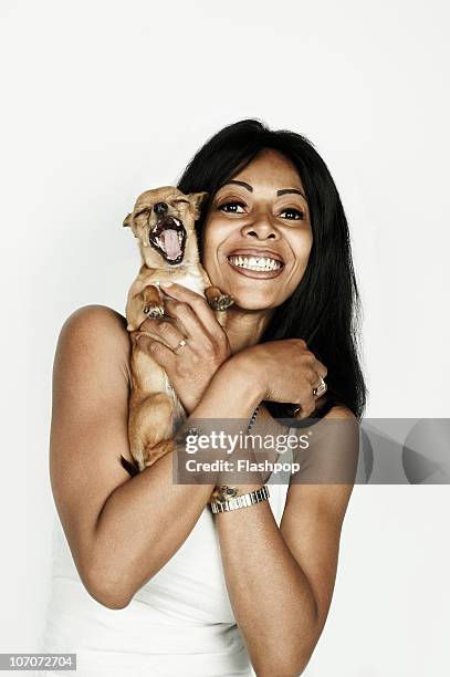 portrait of a woman holding her pet dog - woman holding dog studio stock-fotos und bilder