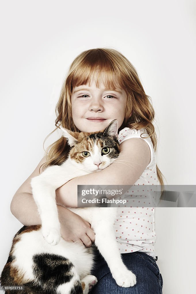 Portrait of girl hugging her pet cat