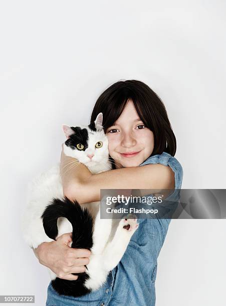 portrait of girl hugging pet cat - girls cuddling cat stock-fotos und bilder