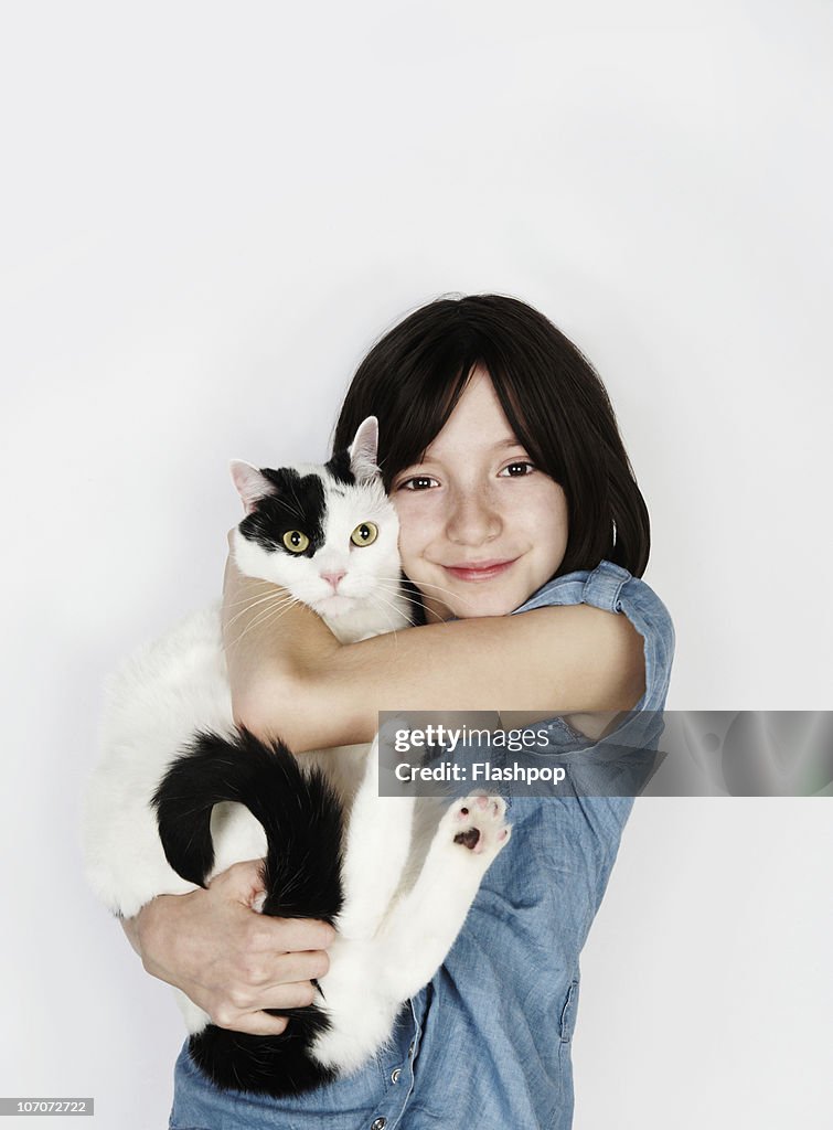 Portrait of girl hugging pet cat