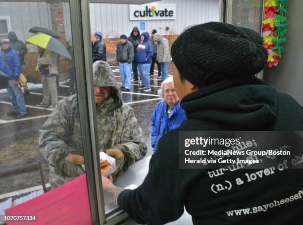 Teri Goulette, owner of grilled cheese food truck Say Cheese!, serves customers as they wait in line outside Cultivate to purchase marijuana products...