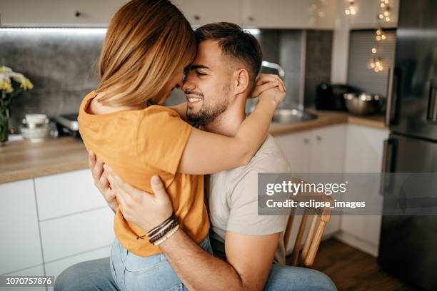 lovely couple having their moment - couple kiss kitchen stock pictures, royalty-free photos & images