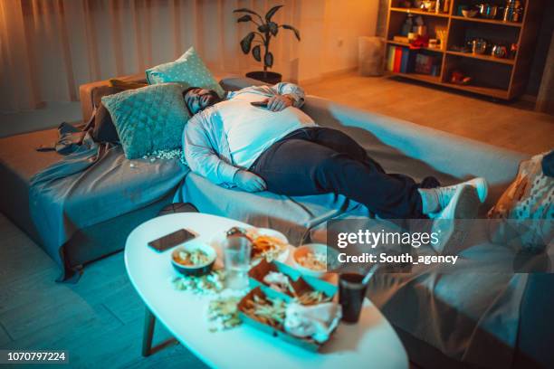 overweight man sleeping on sofa - sleeping posture stock pictures, royalty-free photos & images