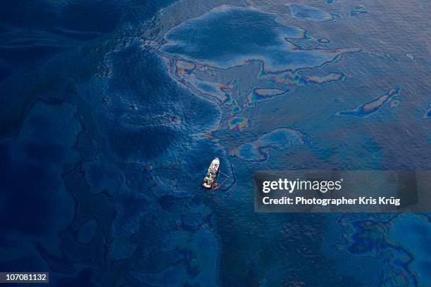 white boat in oil covered water of gulf of mexico - erdöl stock-fotos und bilder