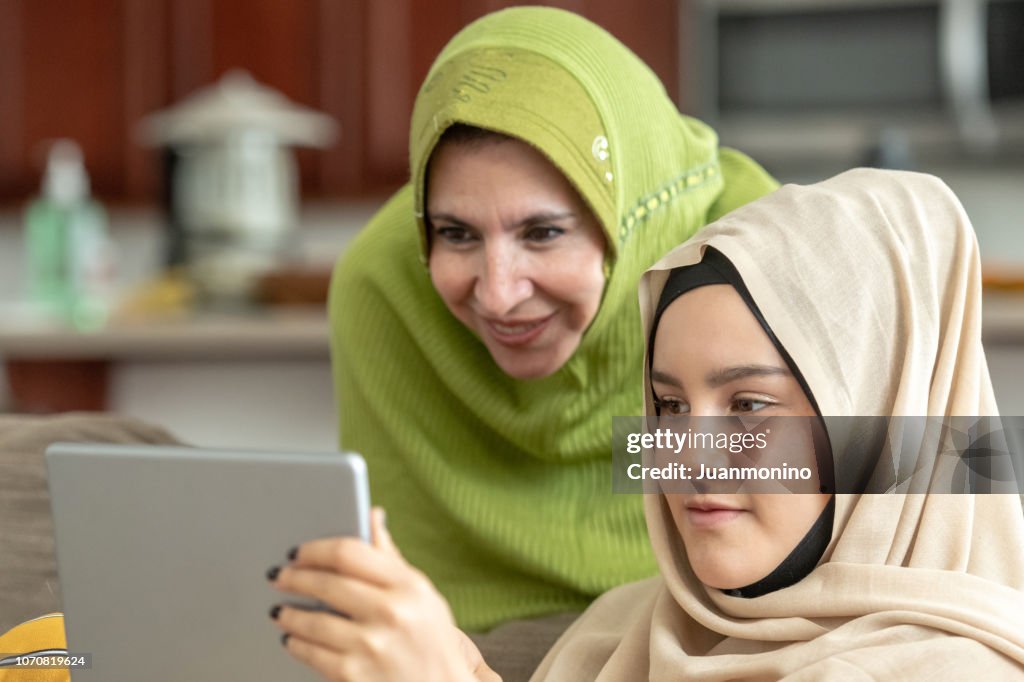 Muslim mature woman posing with her young daughter