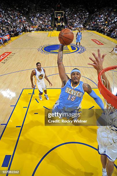 Carmelo Anthony of the Denver Nuggets soars through the air for a dunk over the Golden State Warriors on November 22, 2010 at Oracle Arena in...