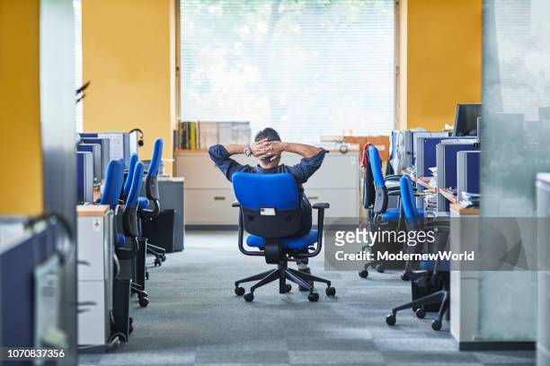 a man having chair still by the window in the office - empty office one person stock pictures, royalty-free photos & images