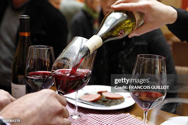 Person pours a glass with Beaujolais Nouveau wine on November 18, 2010 in a wine merchant shop in Paris, during the 2010 vintage Beaujolais Nouveau...