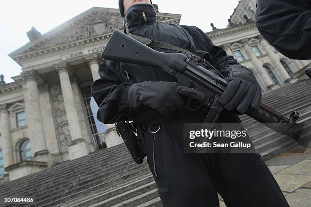 German police armed with submachine guns patrol next to the Reichstag, seat of the Bundestag, or German parliament, on the day Bundestag members...