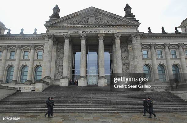 German police armed with submachine guns patrol next to the Reichstag, seat of the Bundestag, or German parliament, on the day Bundestag members...