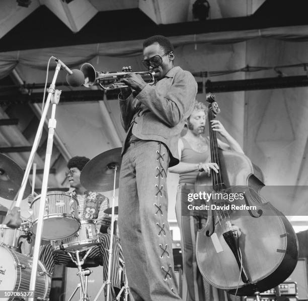 American trumpeter and composer Miles Davis performing at the Newport Jazz Festival at Newport, Rhode Island, 5th July 1969. Behind Davis are Jack...