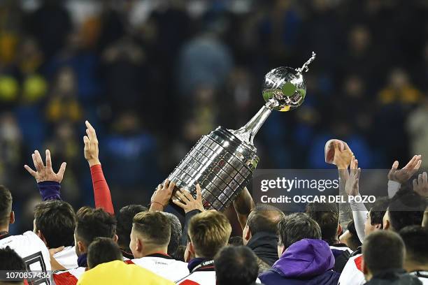 Players of River Plate hold the trophy as they celebrate after winning the second leg match of the all-Argentine Copa Libertadores final against Boca...
