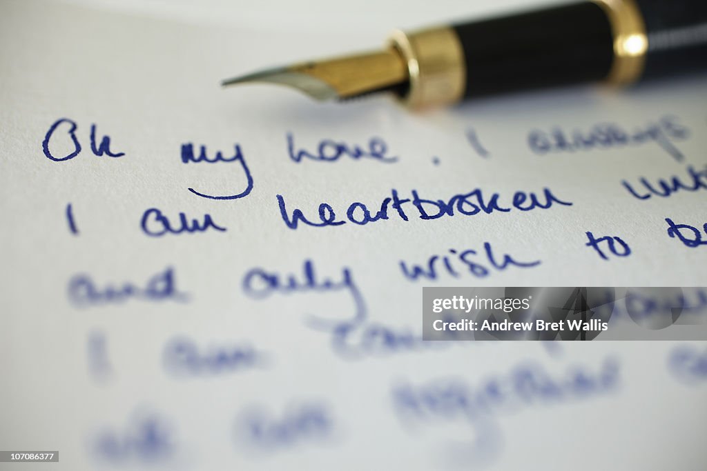 Fountain pen alongside hand written love letter