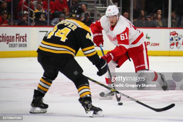 Jacob de la Rose of the Detroit Red Wings looks to get around the defense of Steven Kampfer of the Boston Bruins during the third period at Little...