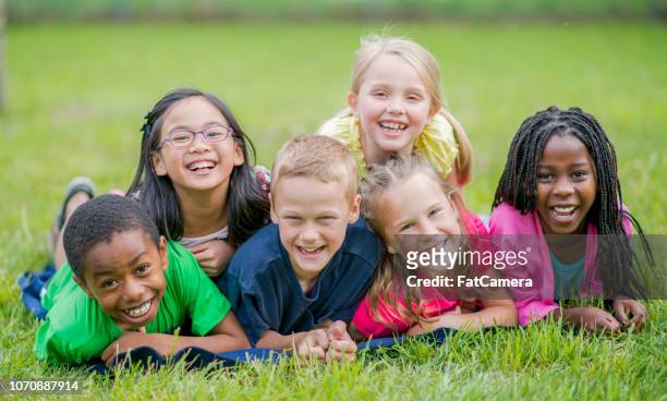 happy children lying in the grass - summer camp kids stock pictures, royalty-free photos & images