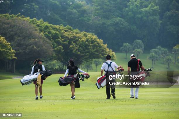 golfers lopen naar het volgende gat - golf caddy stockfoto's en -beelden