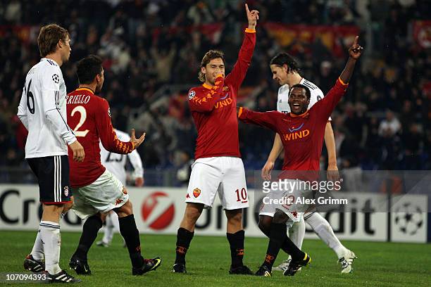 Francesco Totti of Roma celebrates his team's third goal with team mates Marco Borriello and Fabio Simplicio as Martin Demichelis of Muenchen reacts...