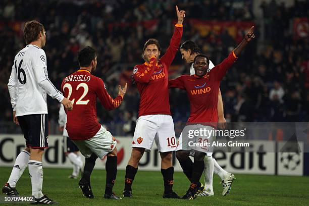 Francesco Totti of Roma celebrates his team's third goal with team mates Marco Borriello and Fabio Simplicio as Martin Demichelis of Muenchen reacts...