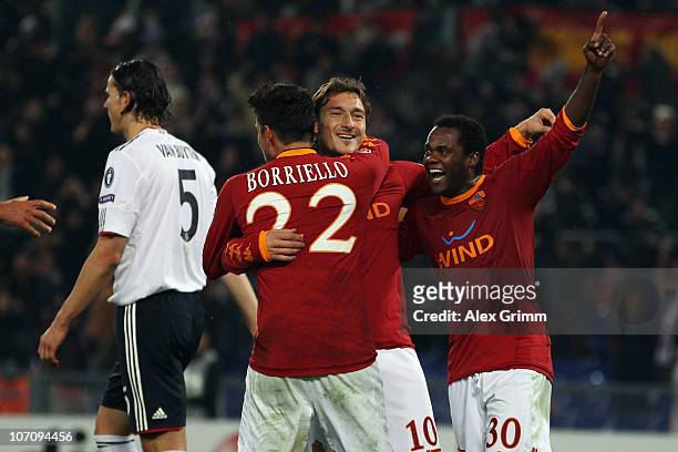 Francesco Totti of Roma celebrates his team's third goal with team mates Marco Borriello and Fabio Simplicio as Daniel van Buyten of Muenchen reacts...