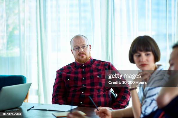 man in plaid shirt in business meeting with colleagues - boring meeting stock pictures, royalty-free photos & images