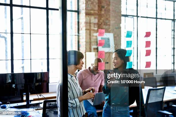 female coworkers problem solving in modern office - problem solving stock pictures, royalty-free photos & images