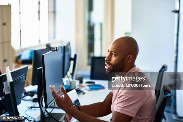 serious businessman with beard at desk explaining - complaining foto e immagini stock