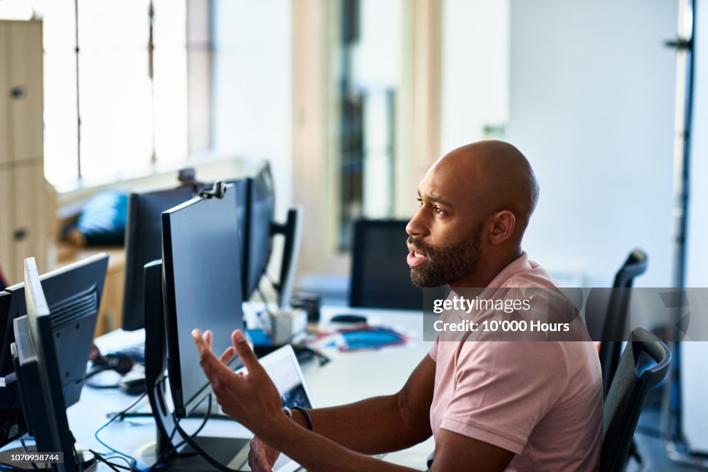 Serious businessman with beard at desk explaining