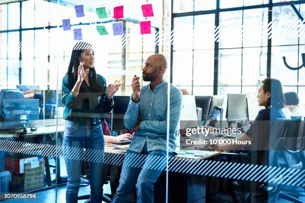 confident chinese woman talking to colleague in office - business chinese men talking stockfoto's en -beelden