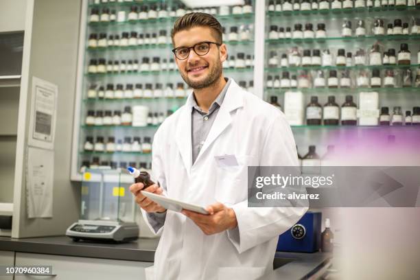 gelukkig mannelijke apotheker bij apotheek - homeopathie stockfoto's en -beelden