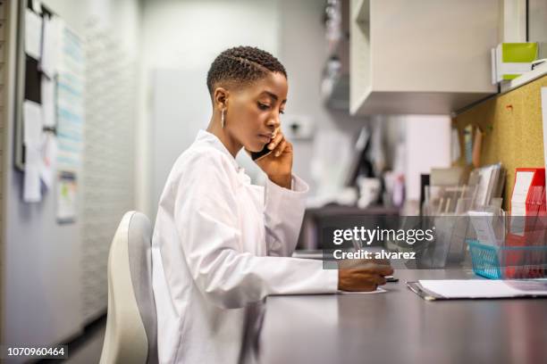 female pharmacist working at pharmacy - pharmacist phone stock pictures, royalty-free photos & images
