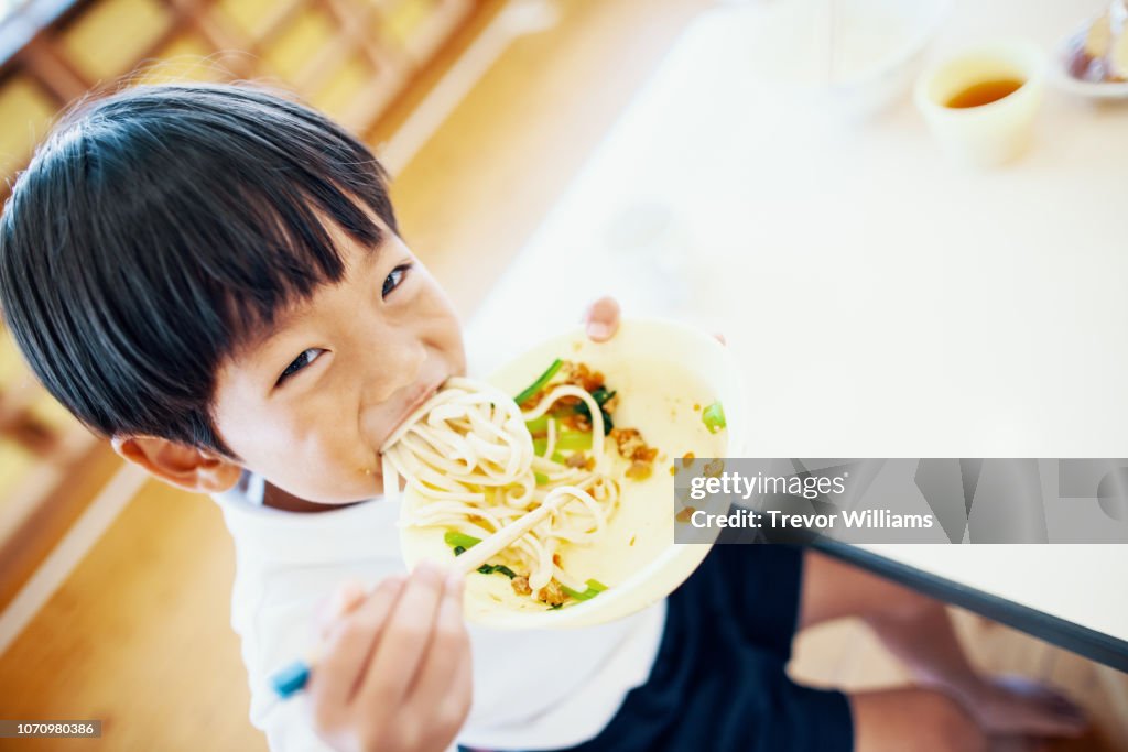 Young boy eating his school lunch at preschool