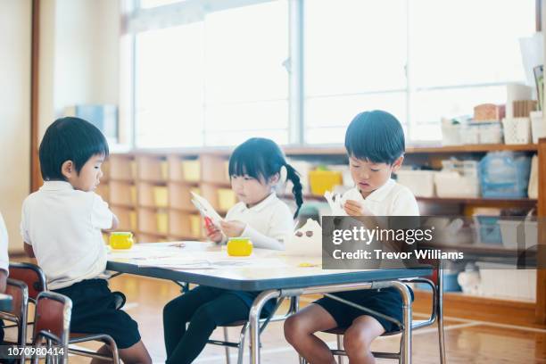 young children doing arts and crafts at preschool in japan - kinder muster fotografías e imágenes de stock