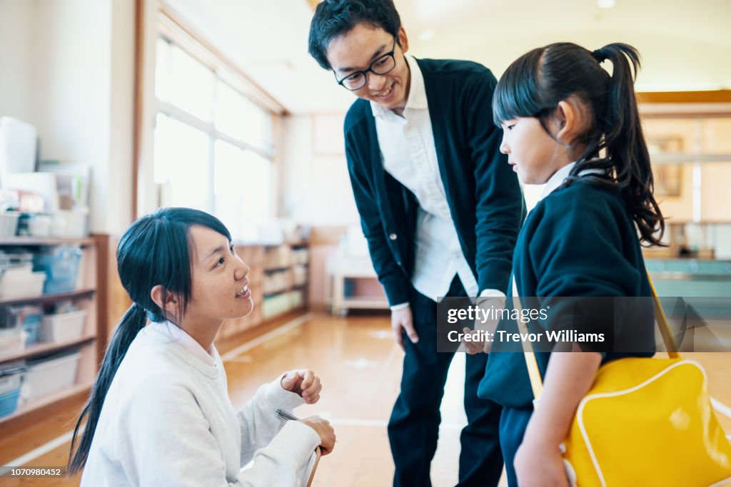 Father dropping off young daughter at preschool