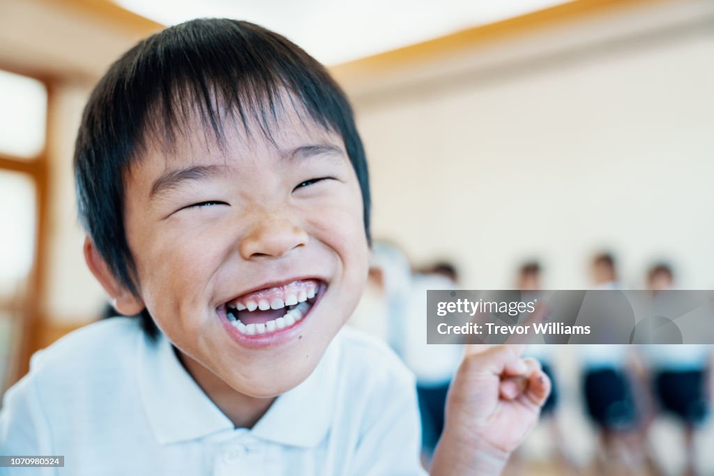 Young boy making a silly face at preschool in Japan