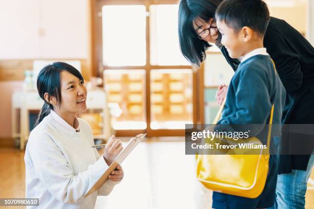 mother dropping off young son at preschool - child care worker stock pictures, royalty-free photos & images