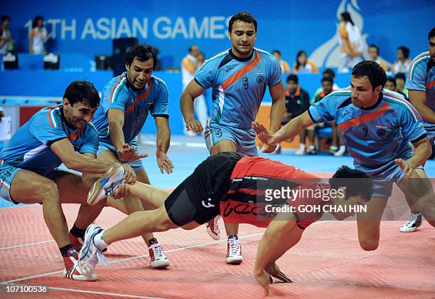 Yang Young-mo of South Korea is taken down by the players from India during the kabaddi men's group A round 3 match at the 16th Asian Games in...